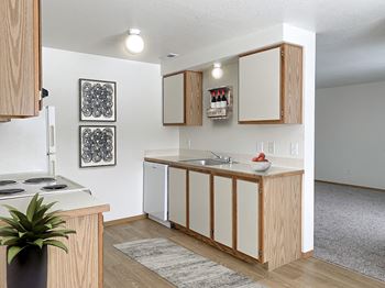 our apartments offer a kitchen with white appliances and wood cabinets at Shiloh Glen, Billings Montana